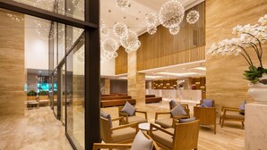 Eine moderne Lobby mit Holzmöbeln, Marmorböden und dekorativer Beleuchtung.