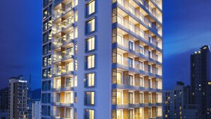 Un hotel moderno de gran altura con múltiples balcones, ventanas amplias y una fachada bien iluminada.