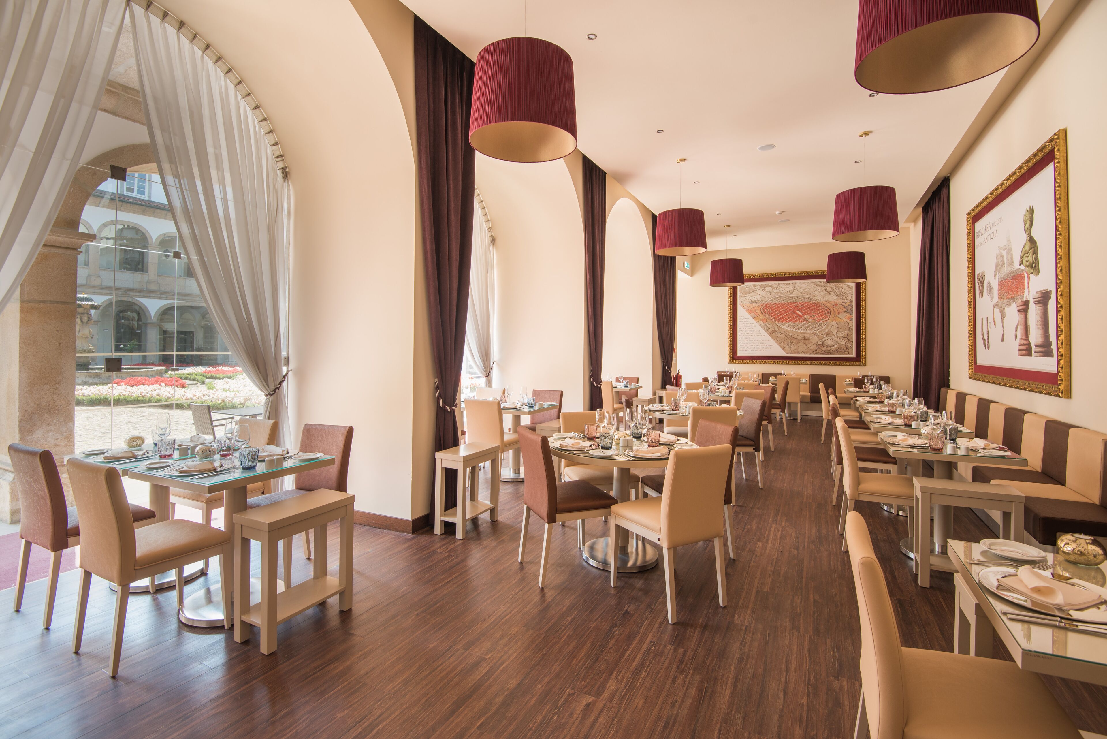 En rummelig restaurant med højt til loftet, store vinduer og elegante lysekroner.
