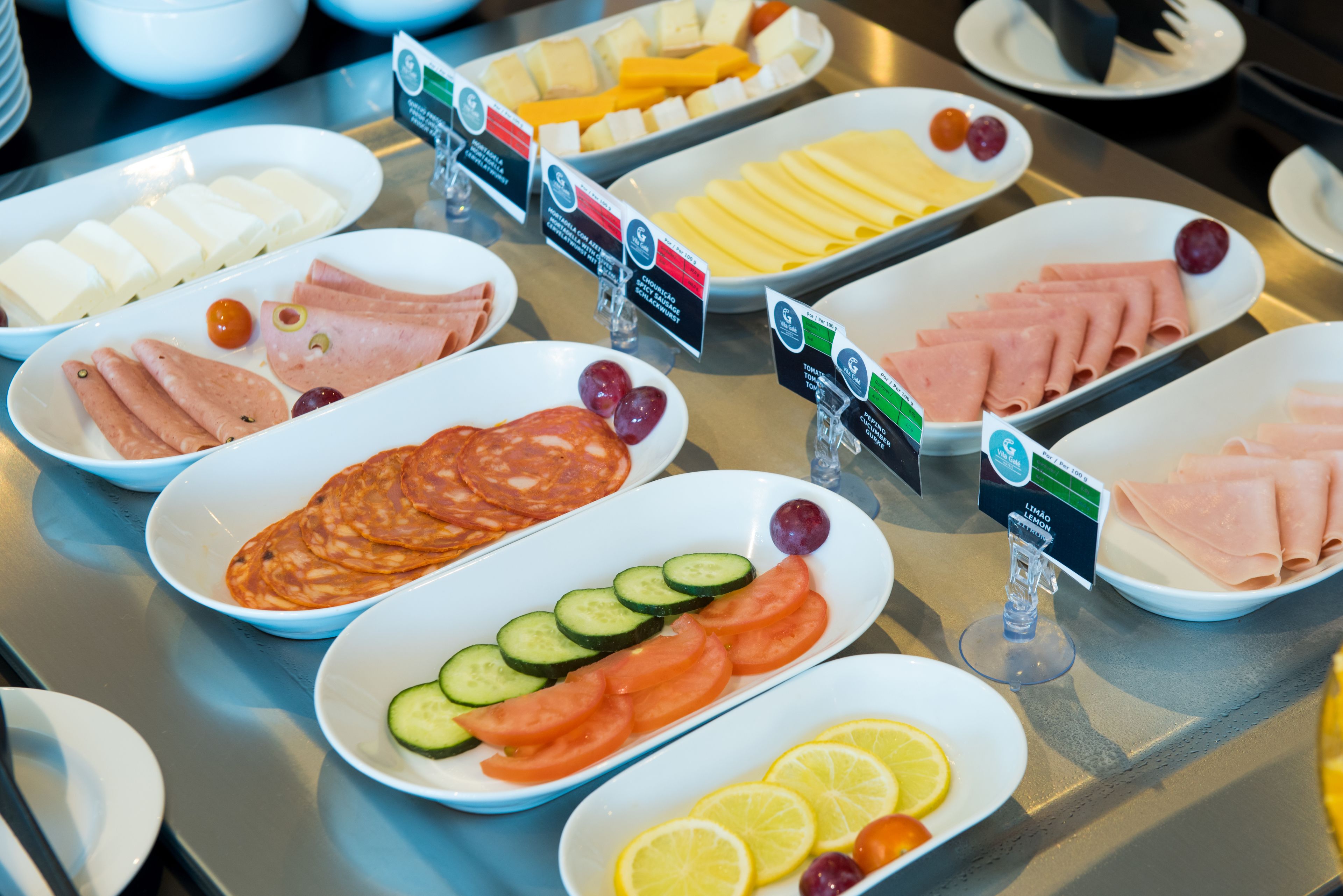 A buffet with various food items including cheeses, meats, and fresh fruits.