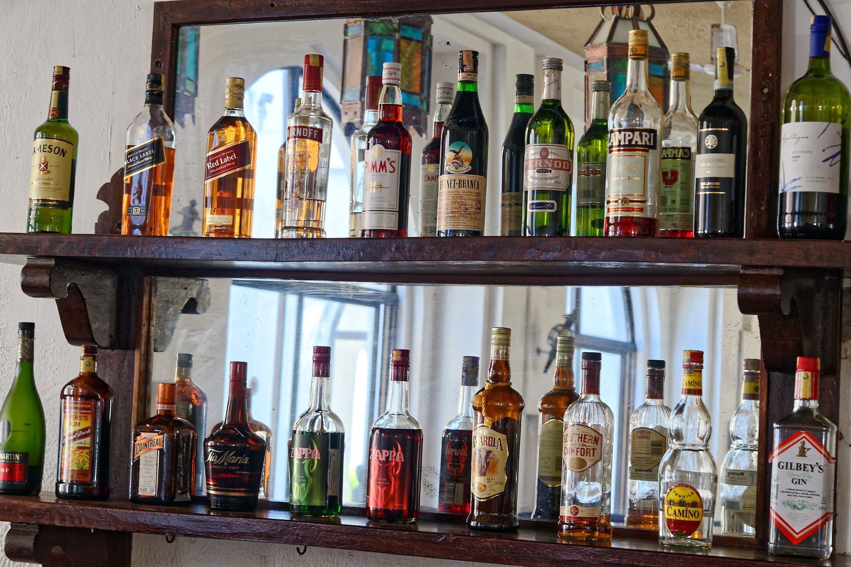 A shelf with various liquor bottles.