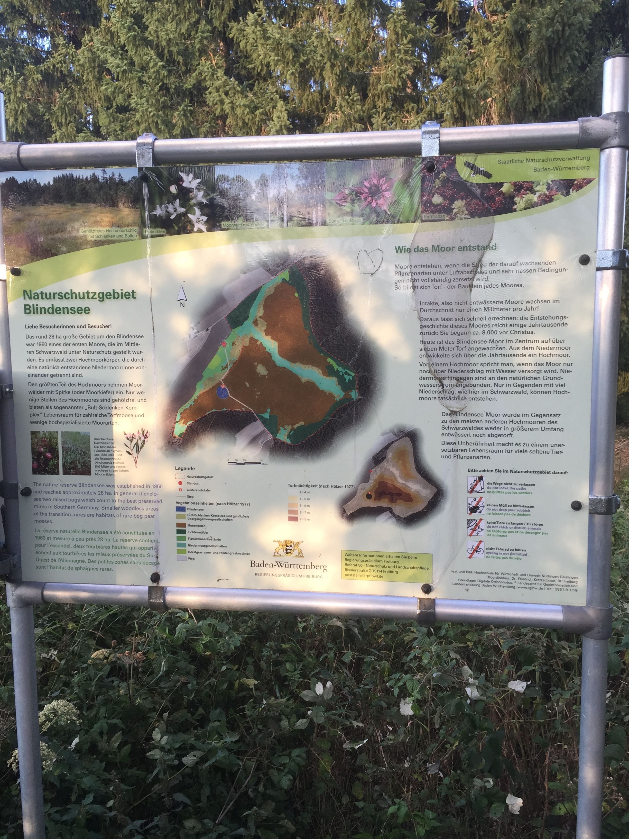 A nature reserve informational sign with a map and text.