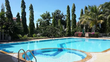 Alberca al aire libre, sombrillas en la alberca y camastros