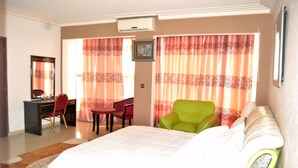 Una habitación de hotel con cama, escritorio, silla y sofá.