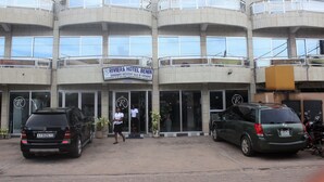 Un hotel de varios pisos con balcones y un cartel que dice "RIVIERA HOTEL BENIN".