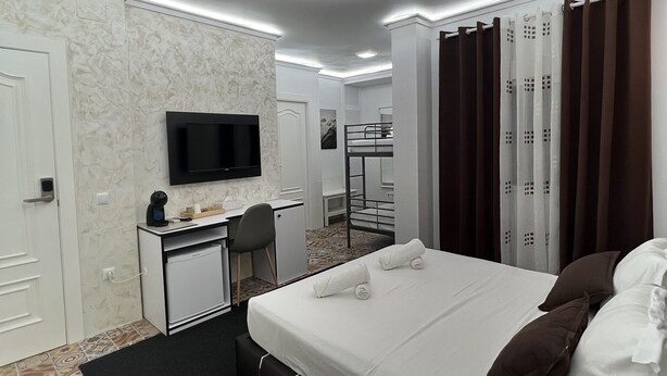 A modern hotel room with a bed, desk, and television. - Hotel Galeón Boutique (Calpe)
