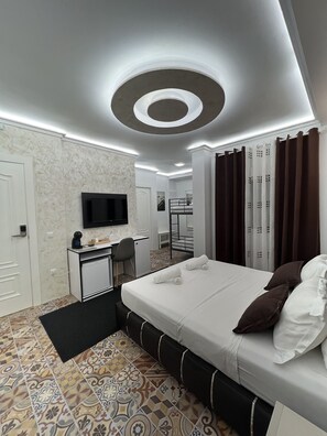 Et moderne hotelværelse med seng, skrivebord og fjernsyn.