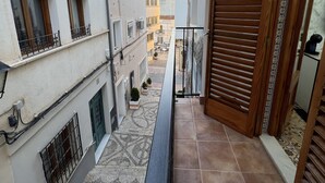 A narrow balcony with a wooden door, a tiled floor, and a view of adjacent buildings. - Hotel Galeón Boutique (Calpe)