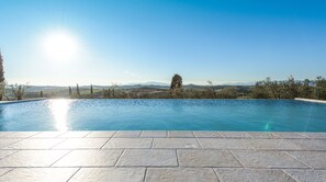 Una piscina con vistas despejadas del paisaje y montañas al fondo.
