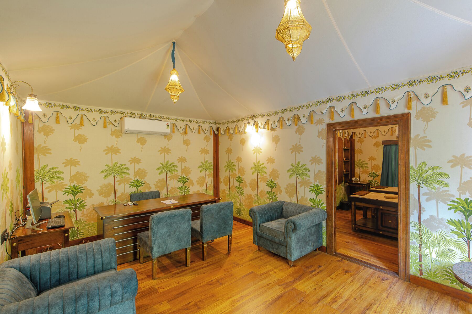 A room with a wooden floor, a dining table with chairs, a sofa, and a mirror.