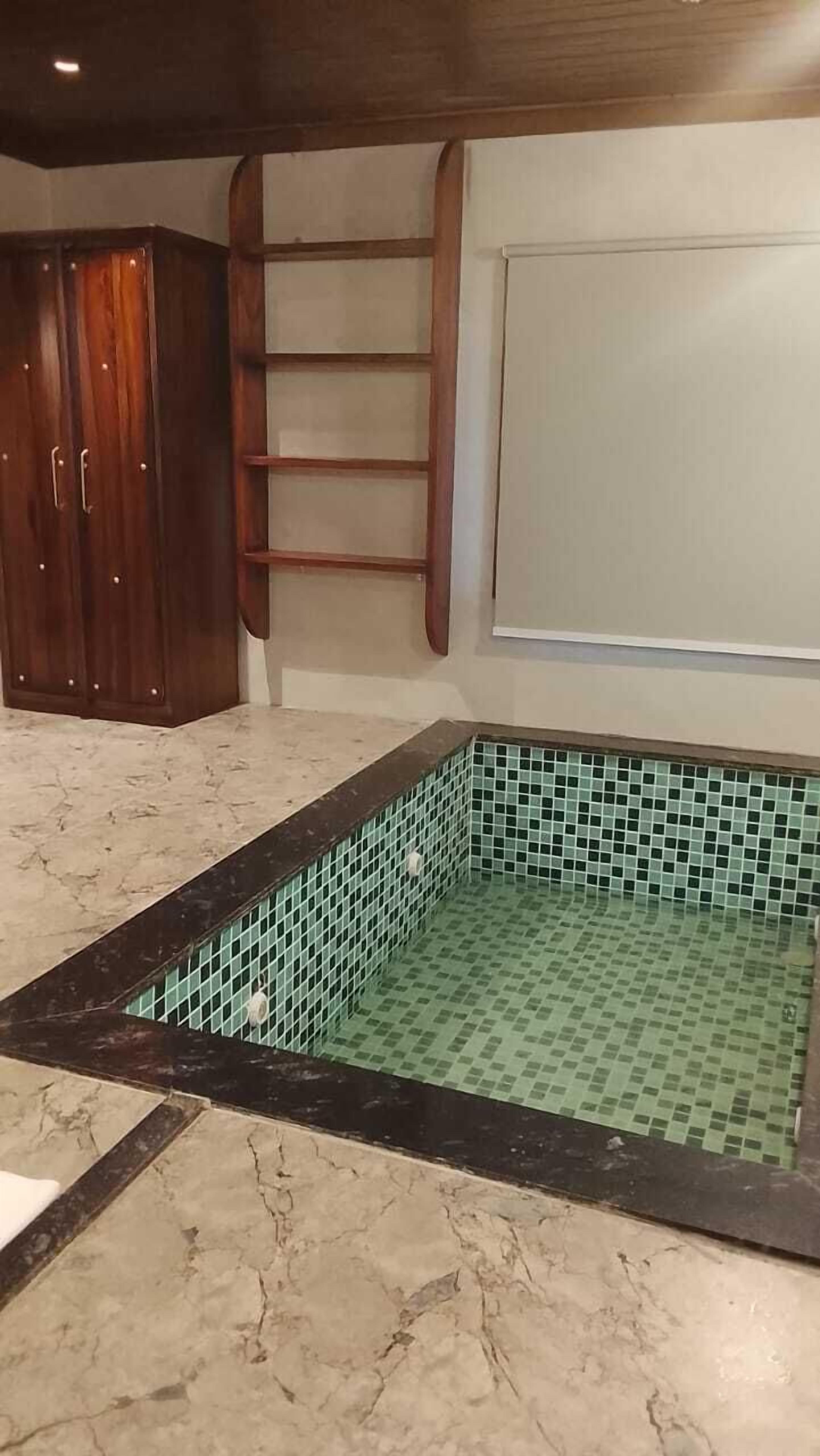 A bathroom with a tiled floor, a wooden cabinet, and a ladder against the wall.