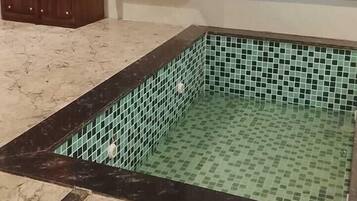 A bathroom with a tiled floor, a wooden cabinet, and a ladder against the wall.