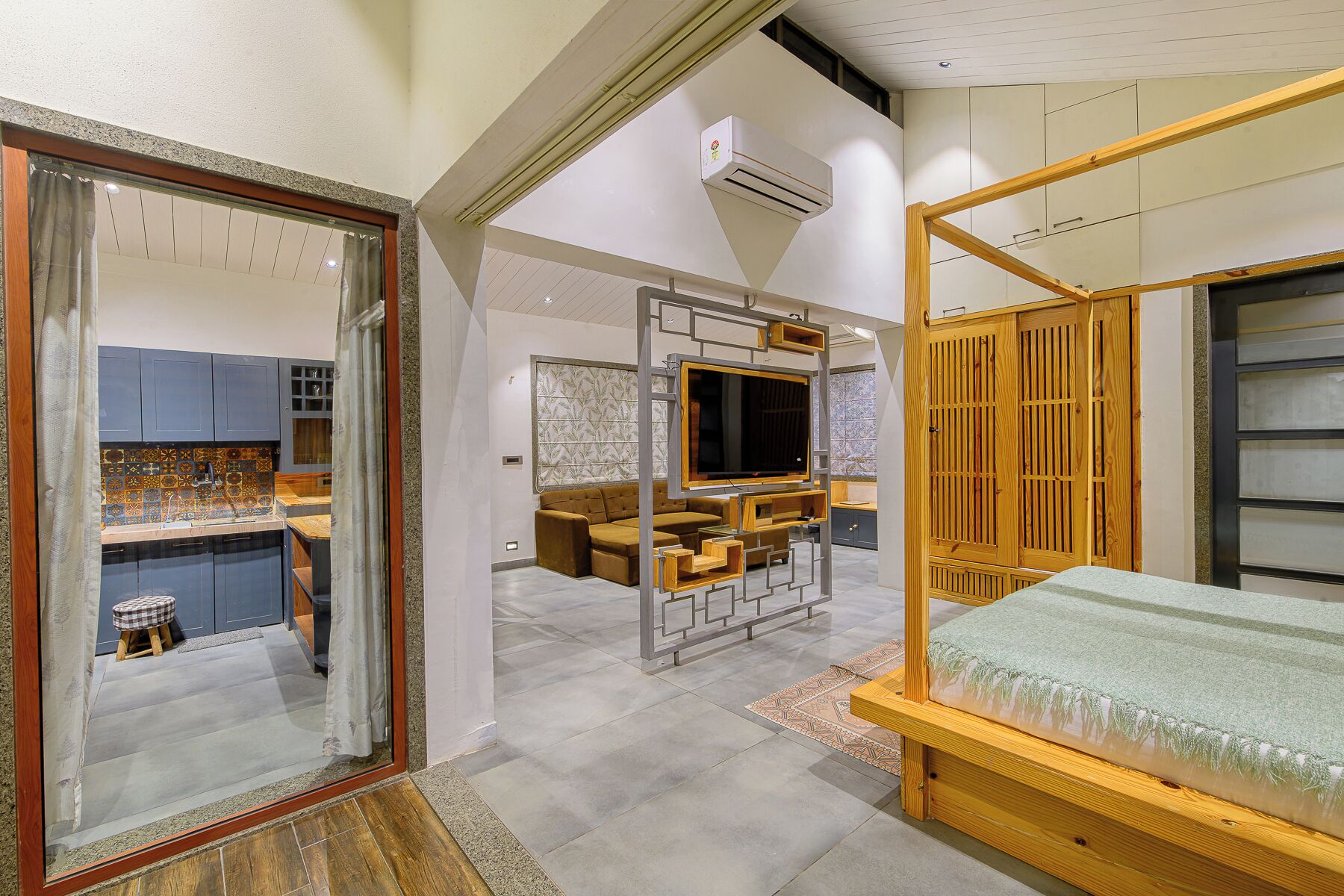 Un interior moderno con una cama, televisor y una zona de cocina.