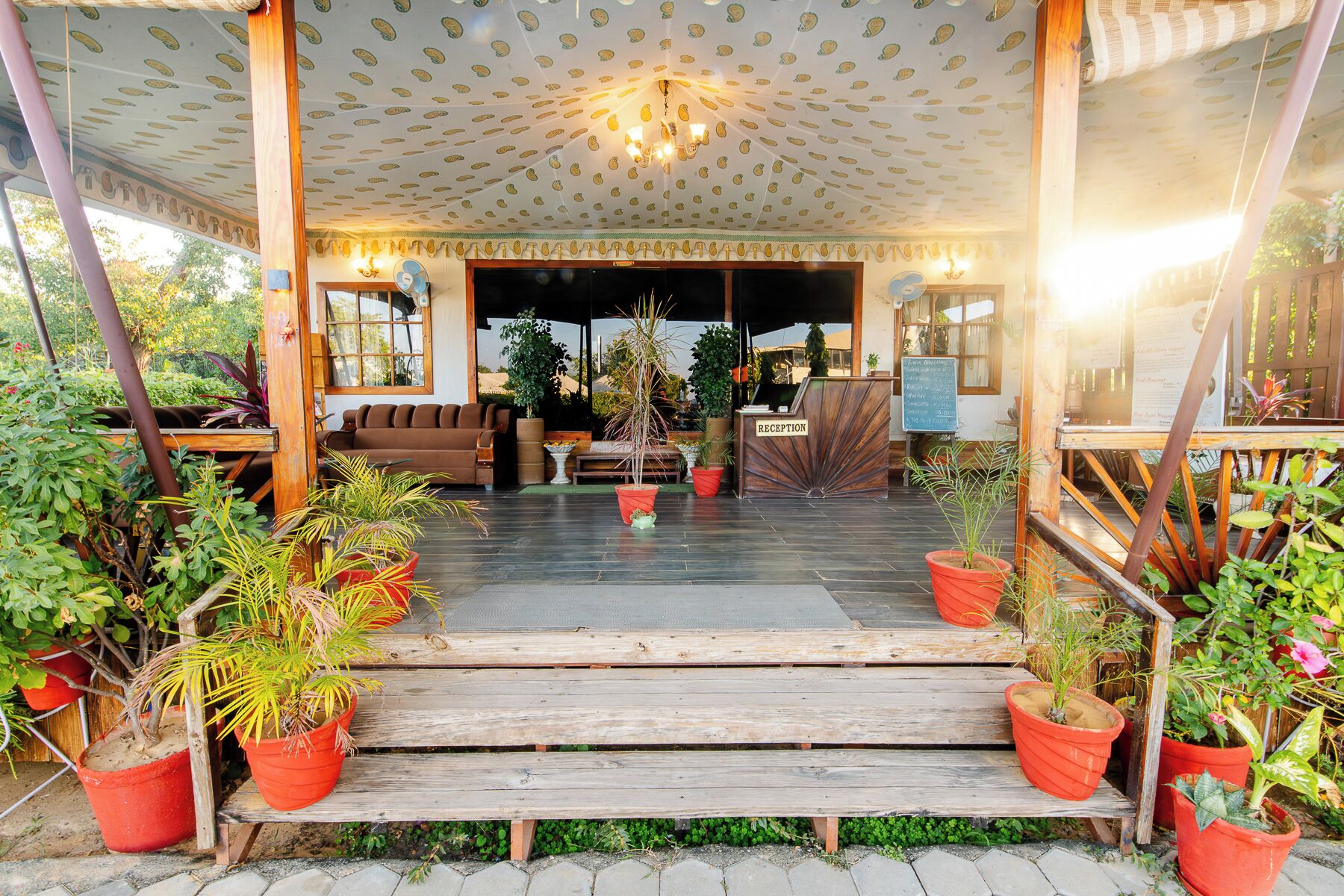 A reception area with a wooden bench, potted plants, and a sign labeled 'RECEPTION'.
