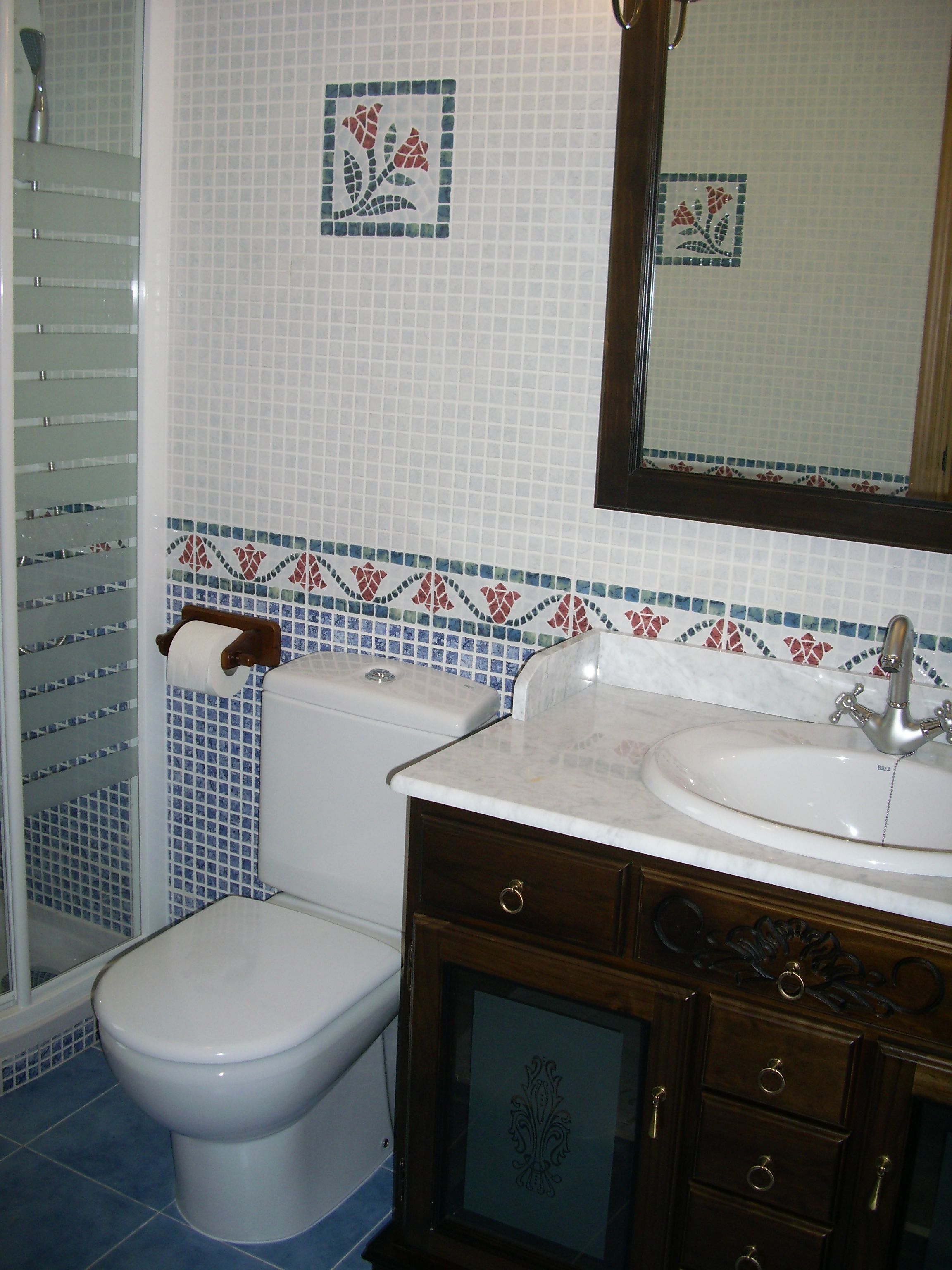 Un baño con inodoro, lavamanos y espejo.