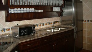 A kitchen with a microwave, sink, and stainless steel refrigerator. - Casa Rural Las Murallas (Brihuega)
