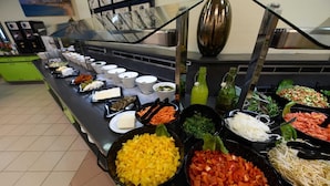 A buffet with various food items including fruits, vegetables, and condiments. - HI Tel Aviv (Tel Aviv)