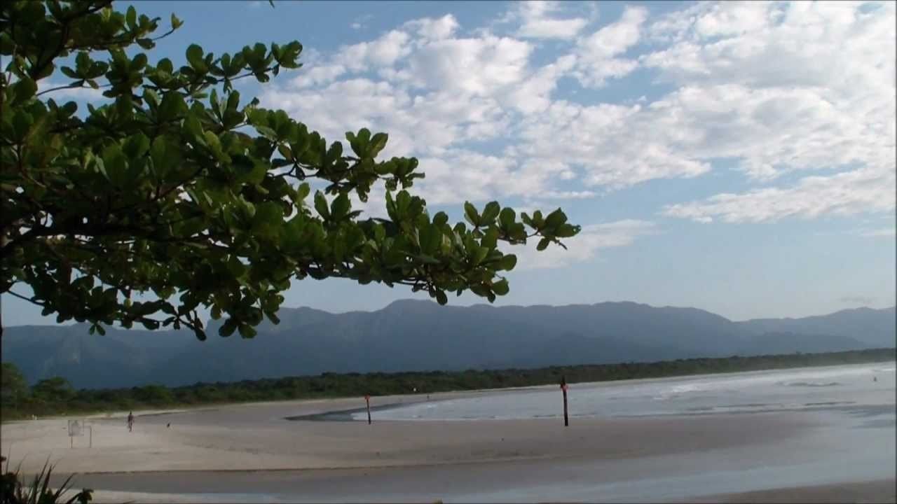 Una spiaggia con cielo sereno e montagne sullo sfondo.