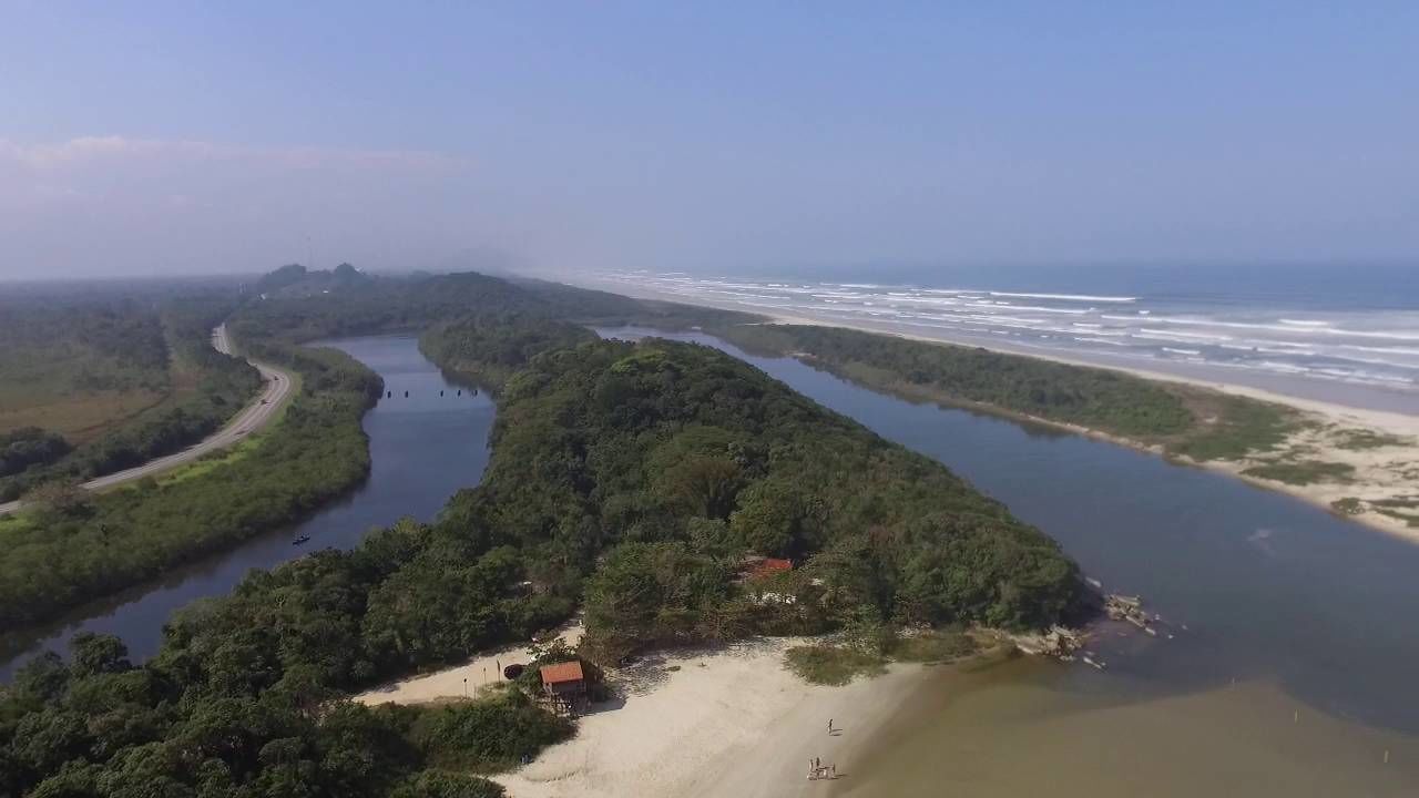 Vista aérea de una zona costera con río, playa y terreno boscoso.