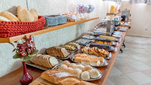 A buffet with various baked goods and pastries. - Bella Casa Flat Service (Bertioga)