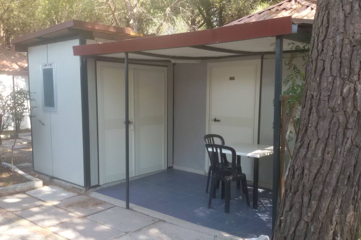 A small, enclosed patio area with a table and chairs, a door, and a window.