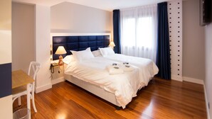 A hotel room with a large bed, a desk, and a chair. - Hotel Boutique Bahía de Plentzia (Plencia)