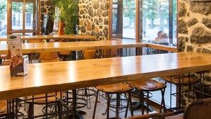 A restaurant with a long wooden bar, stone walls, and hanging pendant lights. - Hotel Boutique Bahía de Plentzia (Plencia)