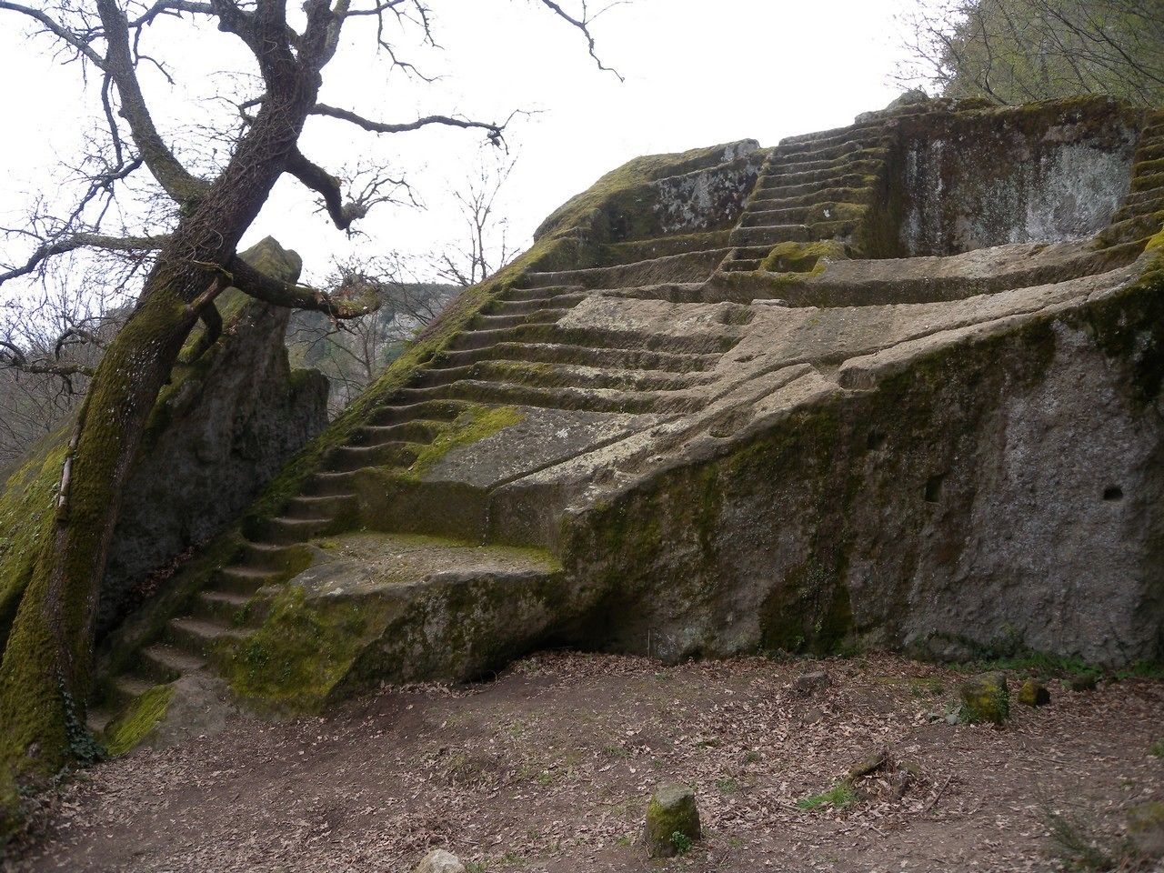 A set of stone steps leading up to a large rock formation.