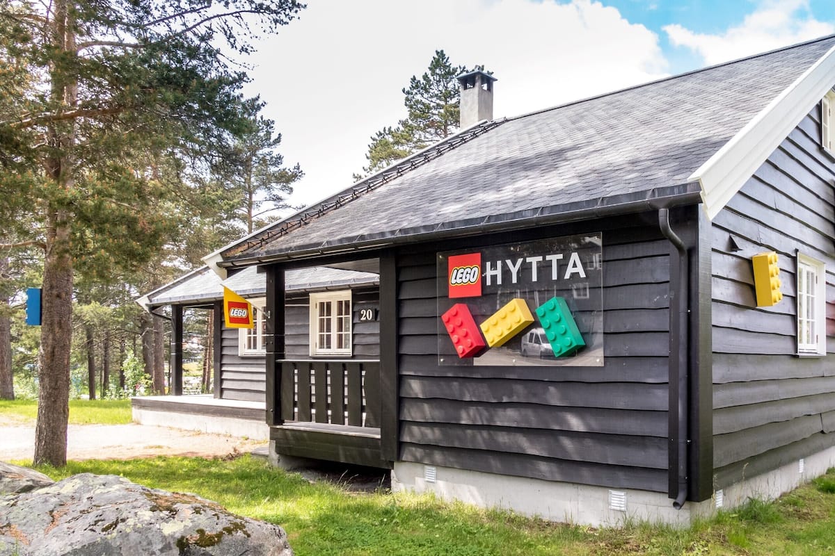A wooden cabin with a sign reading "HYTTA" and LEGO blocks displayed on the window.