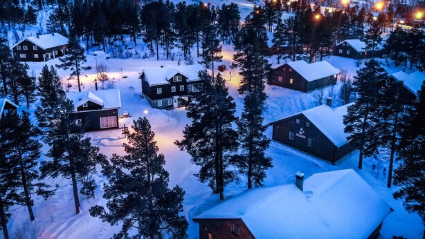 Un village enneigé avec des maisons et une piste de ski.