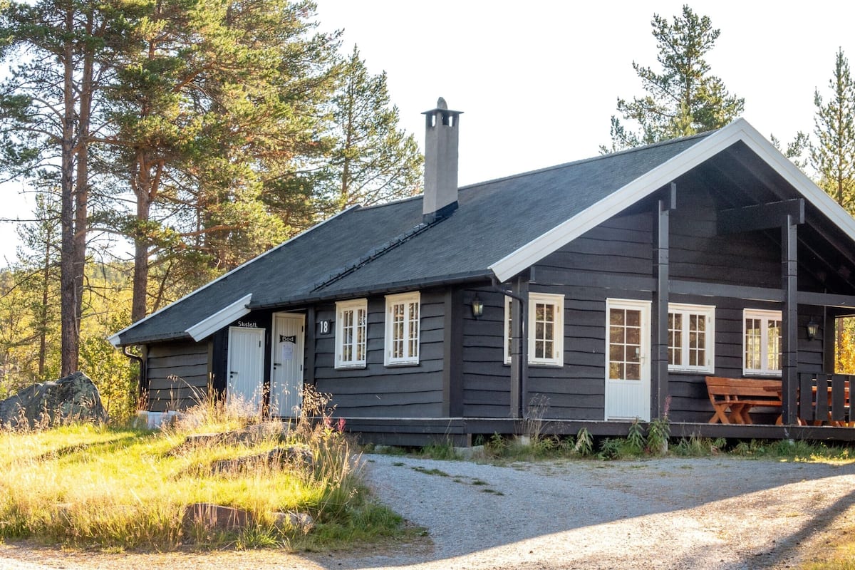 A rustic cabin with a porch, a chimney, and a number '18' on the door.