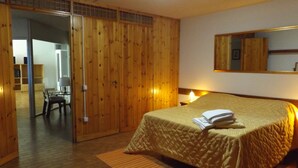 A room with a bed, wooden wardrobe, and a mirror on the wall. - Villa Bardino (Torri del Benaco)