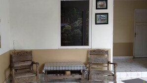 Une pièce avec une table à carreaux, deux chaises en bois, une fenêtre et une porte.