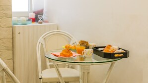 A breakfast setup with pastries, a glass of orange juice, and a tray of croissants on a glass table. - B&B alla Ferrovia (Naples)