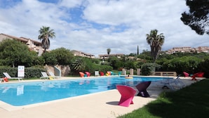 Una piscina con sillas de descanso y un cartel.