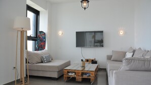 Ett modernt vardagsrum med en soffa, ett soffbord och en golvlampa.