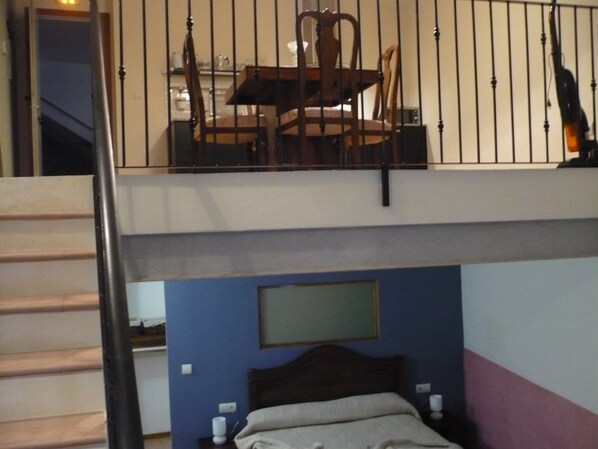 A bedroom with a bunk bed, a desk with a chair, and a balcony with a railing. - Ca L'Estruch (Vallclara)