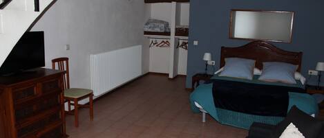Une chambre à coucher comprenant un lit, une commode, une chaise, un miroir et un escalier.