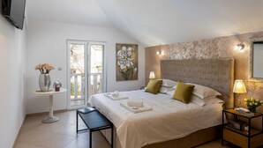 A bedroom with a bed, bedside tables, a TV, and a painting. - Apartments Subrenum (Zupa dubrovacka)