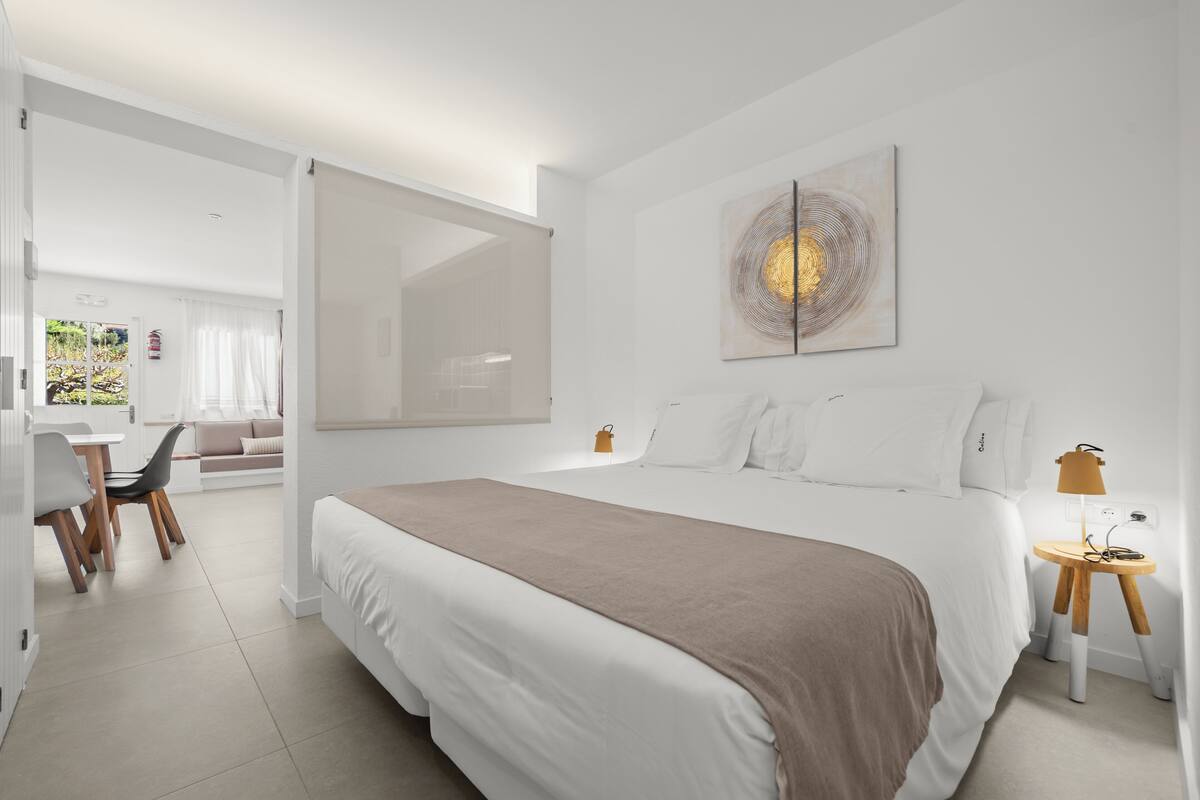 Una habitación de hotel moderna con una cama grande, un escritorio y una silla.