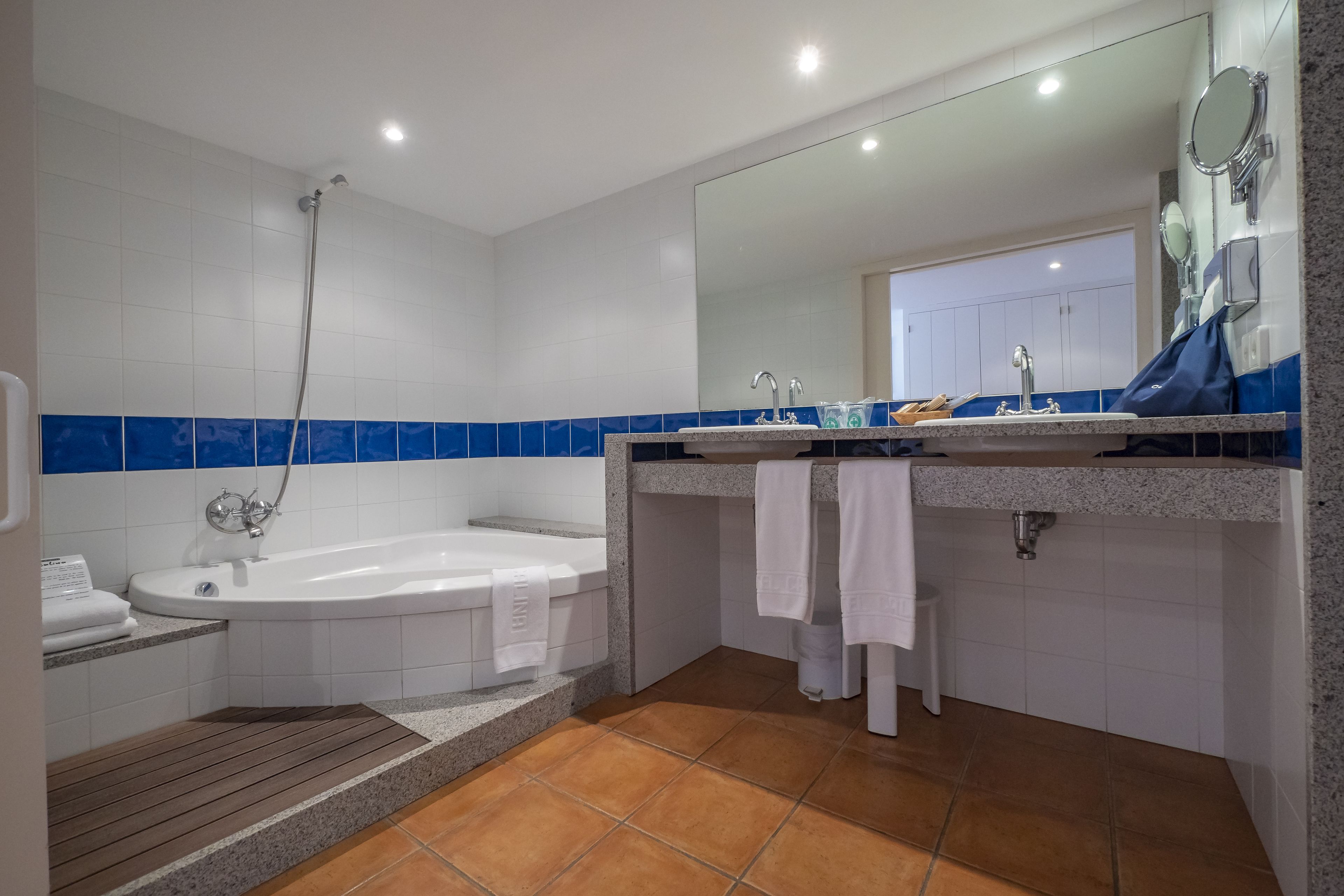 A modern bathroom with a bathtub, a shower, and a sink with a mirror.
