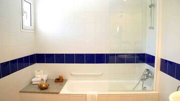 Een badkamer met een bad, een douche en een wastafel.