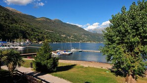Ein Yachthafen mit vertäuten Booten, umgeben von üppigen grünen Hügeln und blauem Himmel.