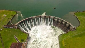 A large dam with water flowing through its gates, surrounded by green fields and a small body of water. - La Cubana Hotel & Residencial (Colon)