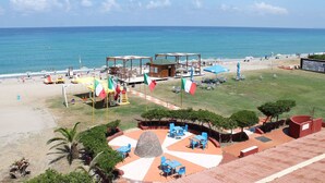 A beachside hotel with outdoor seating, a pool, and a view of the ocean. - Hotel South Paradise (Palmi)