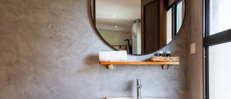 A bathroom with a toilet, a pedestal sink, and a mirror.