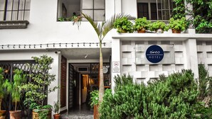 Een hotelentree met een bord waarop 'cinco hotel' staat.