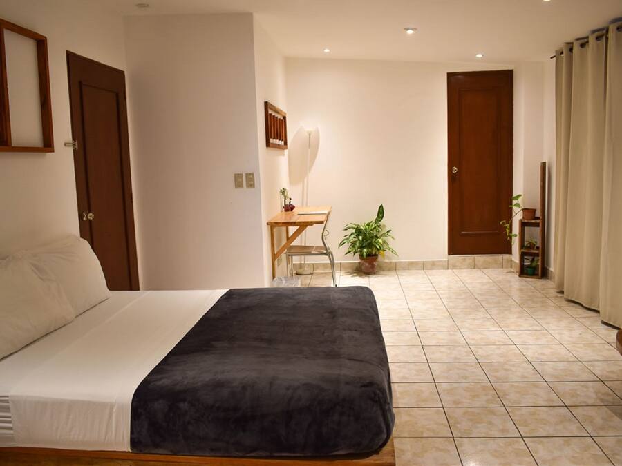A bedroom with a bed, a desk, and a chair.