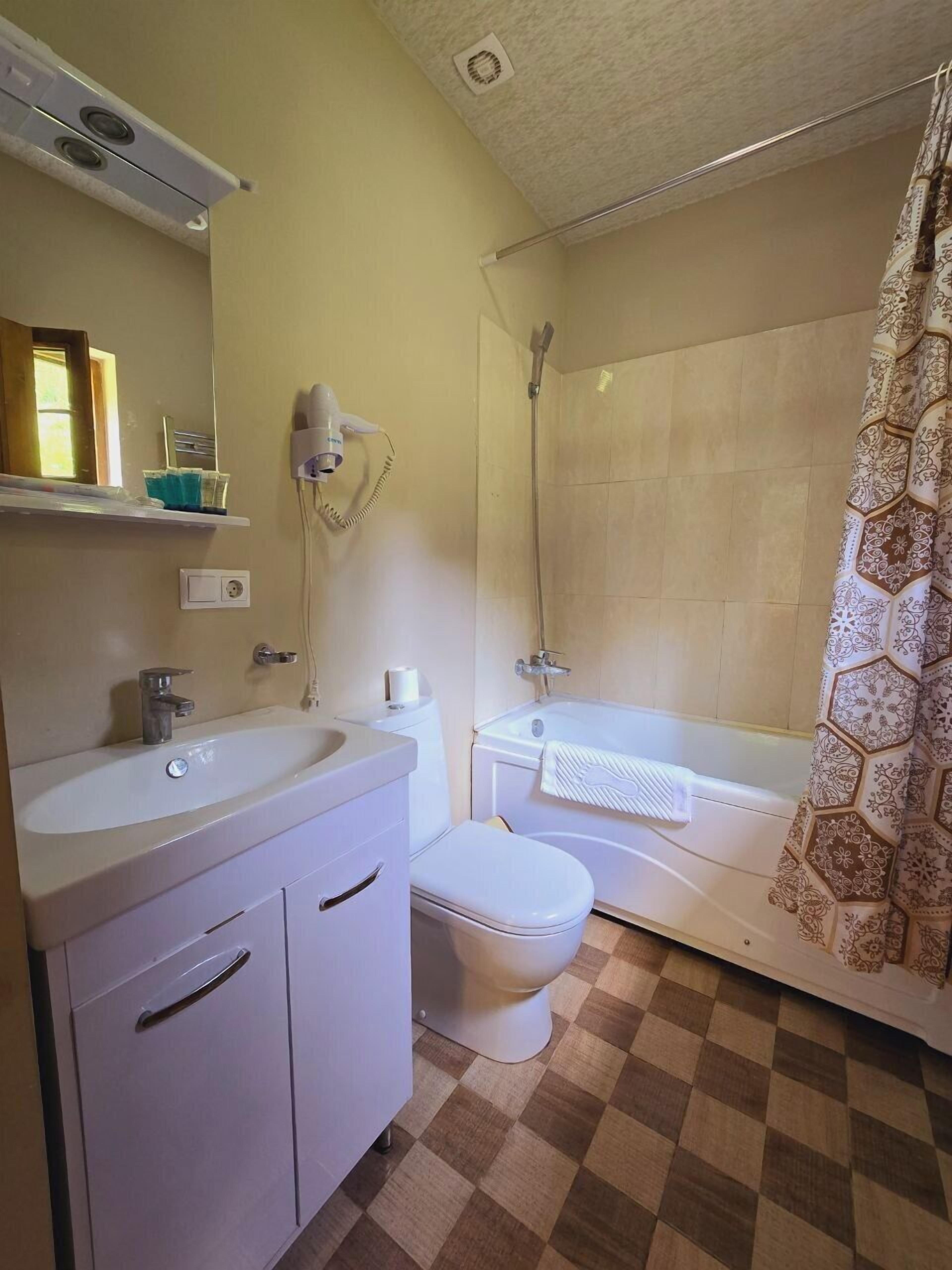 Un baño con lavamanos, inodoro y ducha.