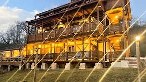 Un immeuble en bois à plusieurs étages, doté de balcons et d’un chemin en pierre menant à l’entrée.